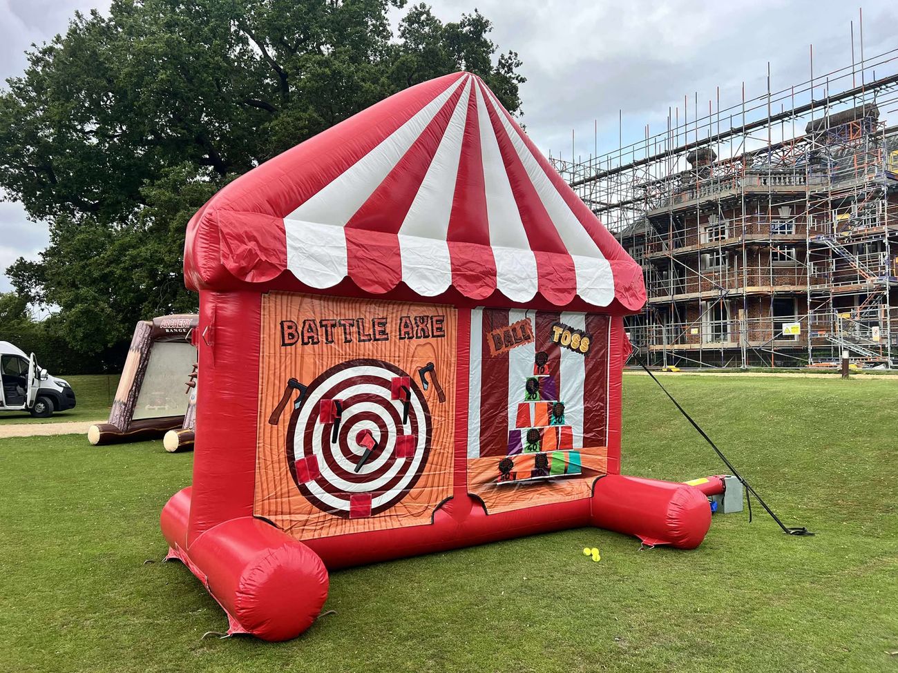 Side view of the carnival game's battle axe and ball toss panels under the canopy