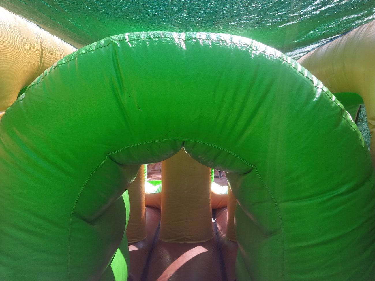 Interior green inflatable archway with yellow supports inside the assault course