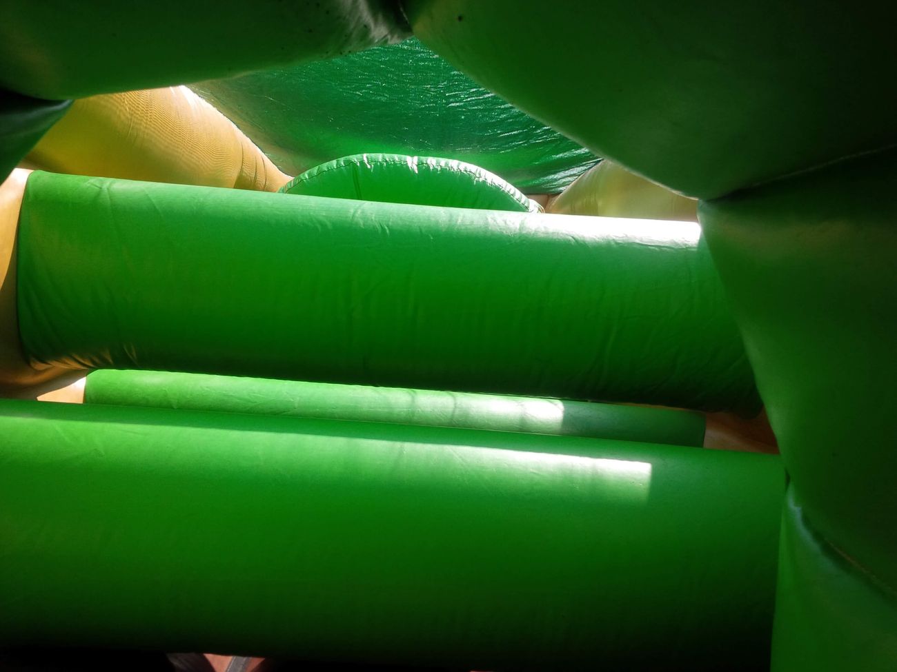 View through green inflatable crawl tubes inside the army assault course