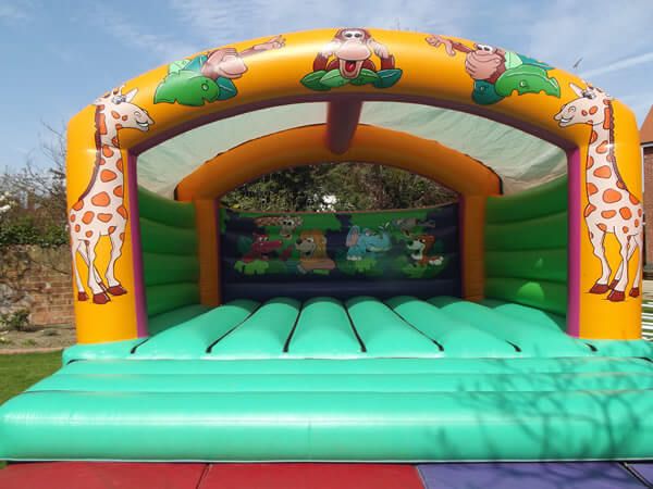20ft animal bouncy castle with giraffes either side and a jungle scene on the back wall