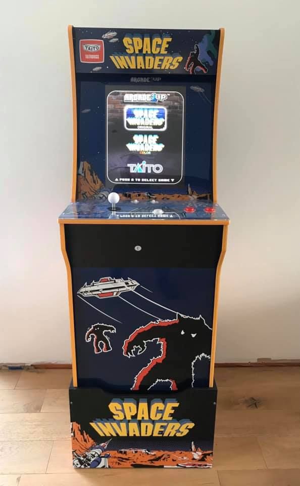 Arcade1Up Space Invaders upright cabinet with orange trim and riser
