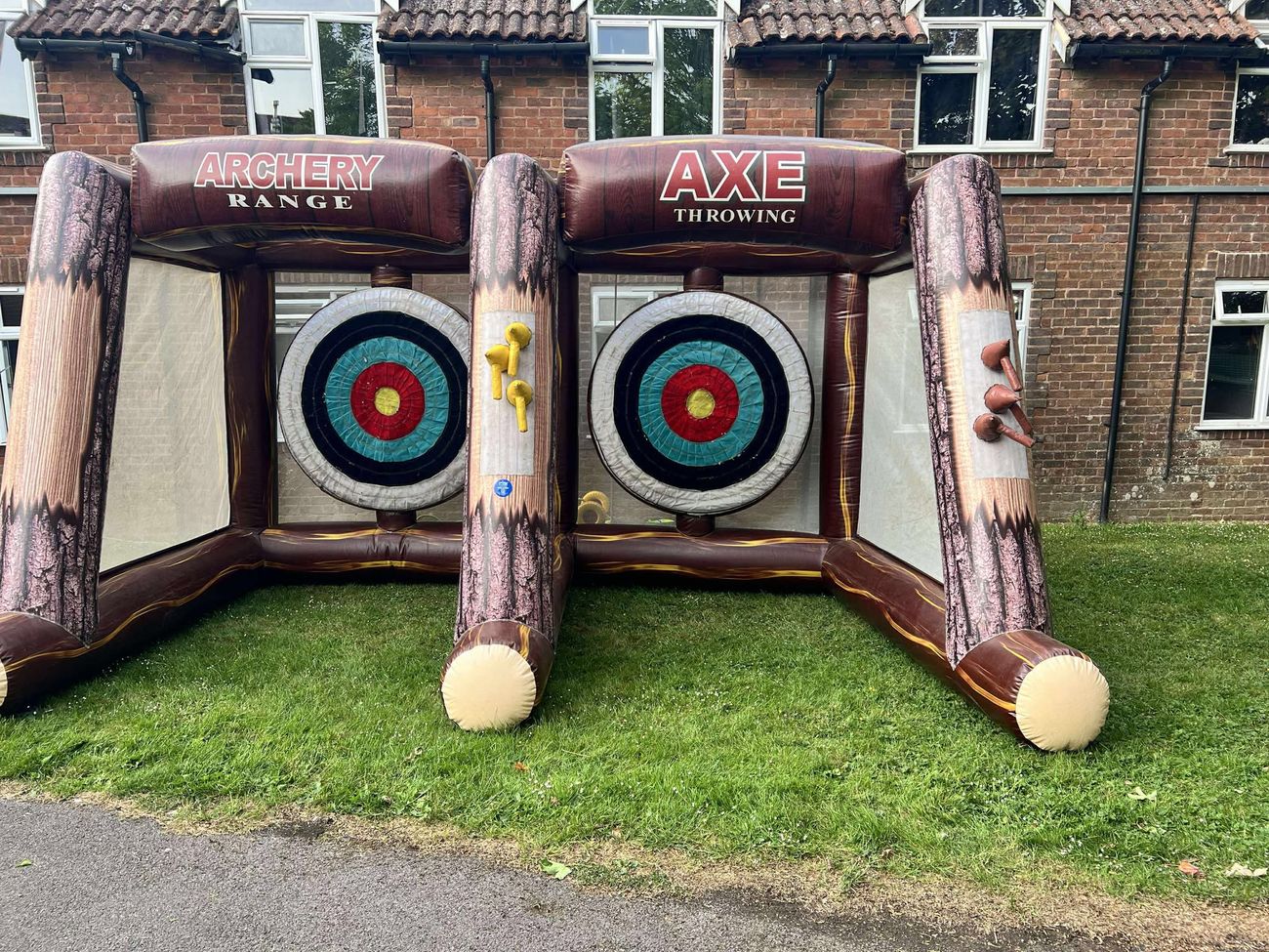 Inflatable axe throwing and archery range with two target lanes set up on grass