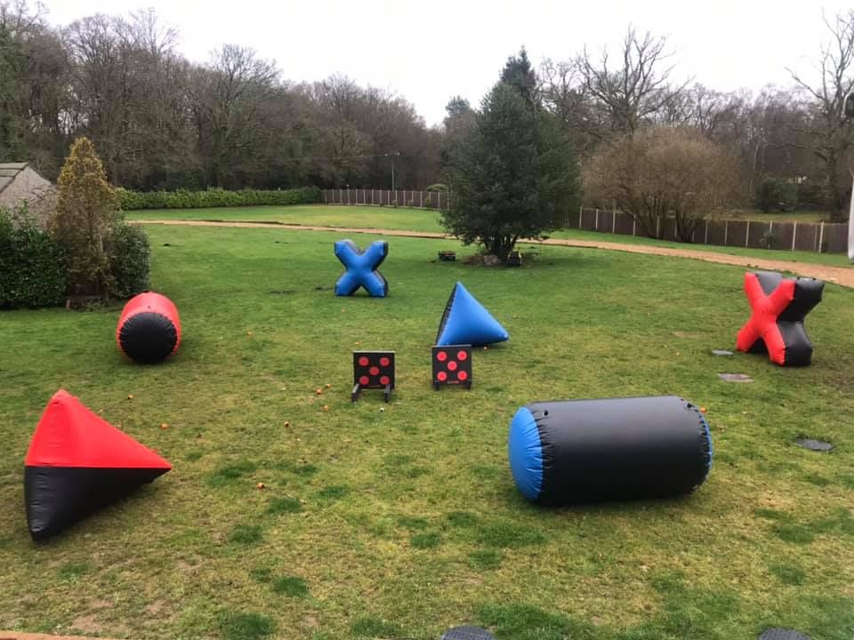 Combat archery arena with colourful inflatable bunkers and target boards on a grass field