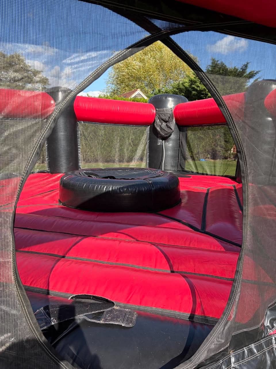 Inside the Dash N Grab arena, red floor and central ball pit seen through the mesh entrance