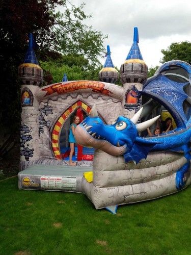 Dragon Age bouncy castle with blue dragon head, garden setup
