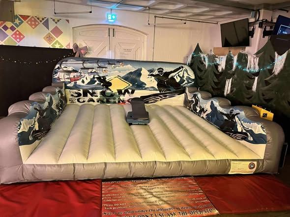 Snowboard simulator set up indoors for a company Christmas party