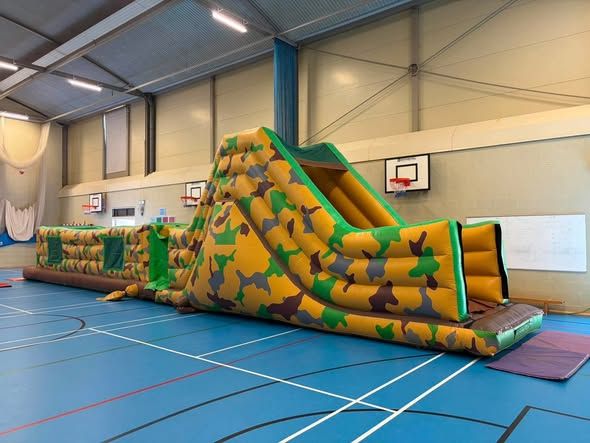 Camouflage inflatable obstacle course inside a Farnborough school sports hall