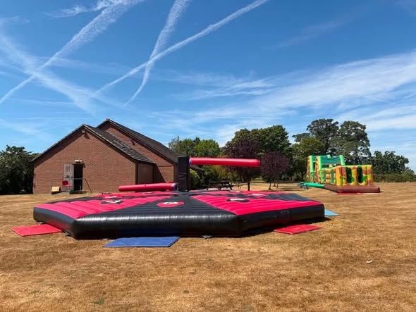 Inflatable sweeper arena and assault course set up on a field in West Sussex
