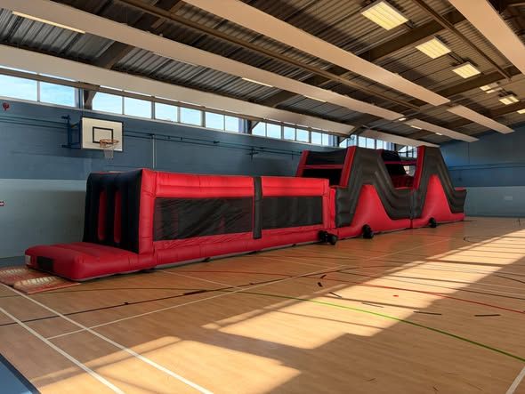 Red and black Big Red assault course set up indoors for a Havant school reward day