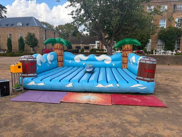 Blue inflatable surf simulator with wave graphics on the grounds of an international school in Surrey