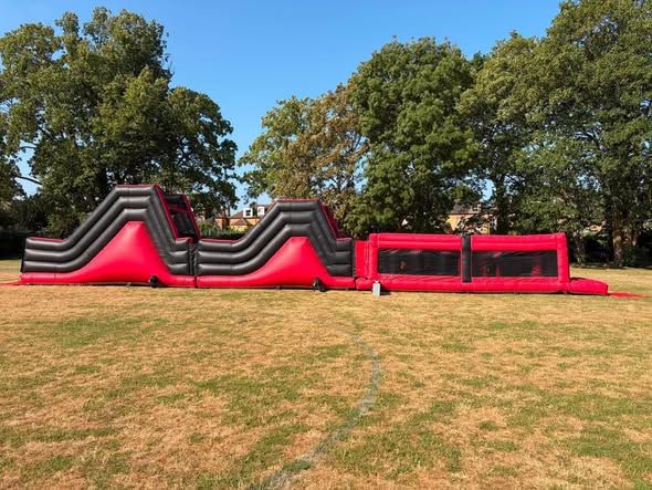 Red and black Big Red assault course on a school field in Twickenham