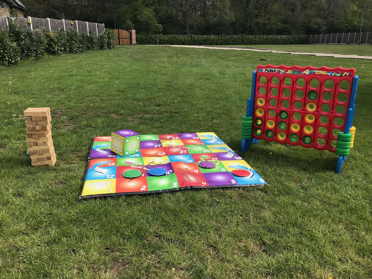 Giant Jenga, giant snakes and ladders and giant Connect 4 set up on grass
