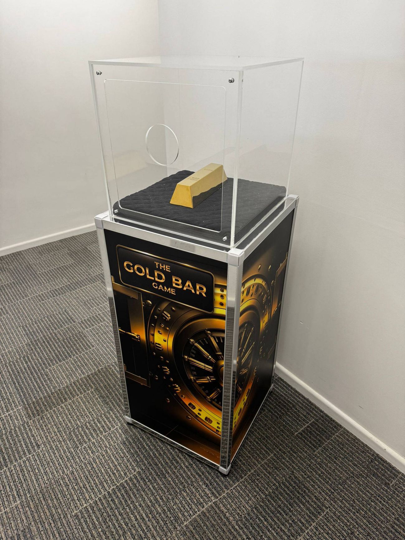 Gold bar game: acrylic case with a gold bar inside, on a plinth printed with vault artwork