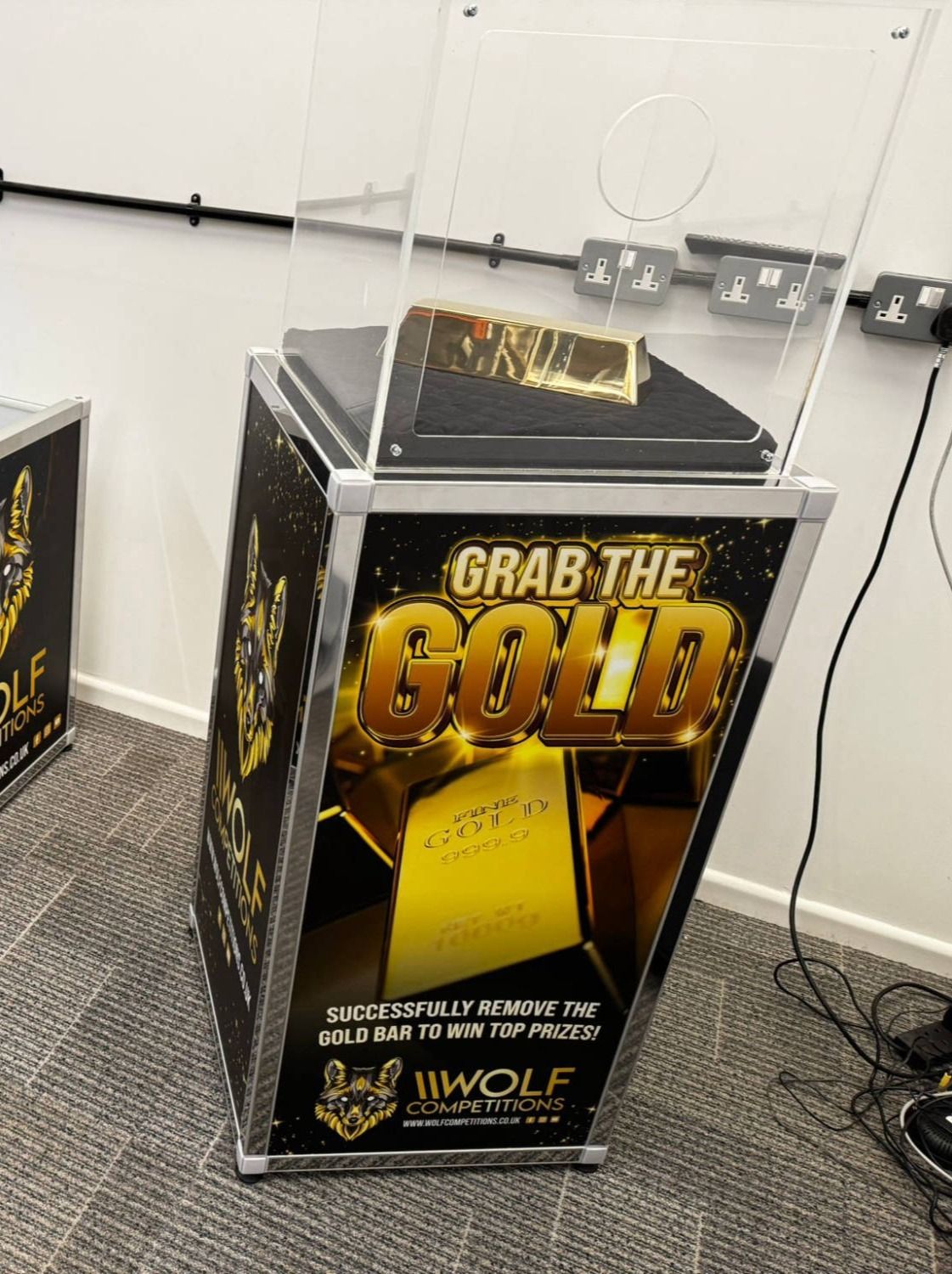 Gold bar game unit branded Grab the Gold, gold bar on its cushion inside the case