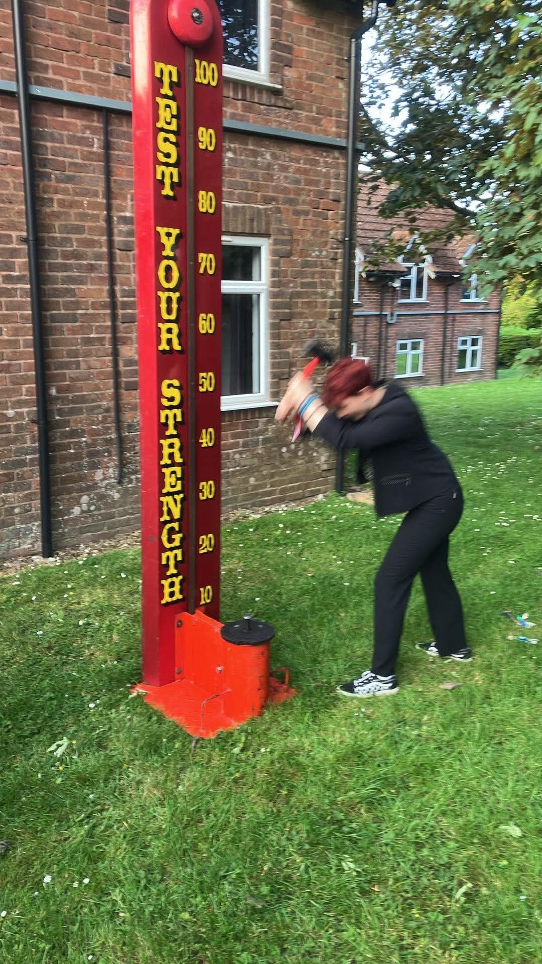 Player swinging the mallet at the High Striker fairground strength tester