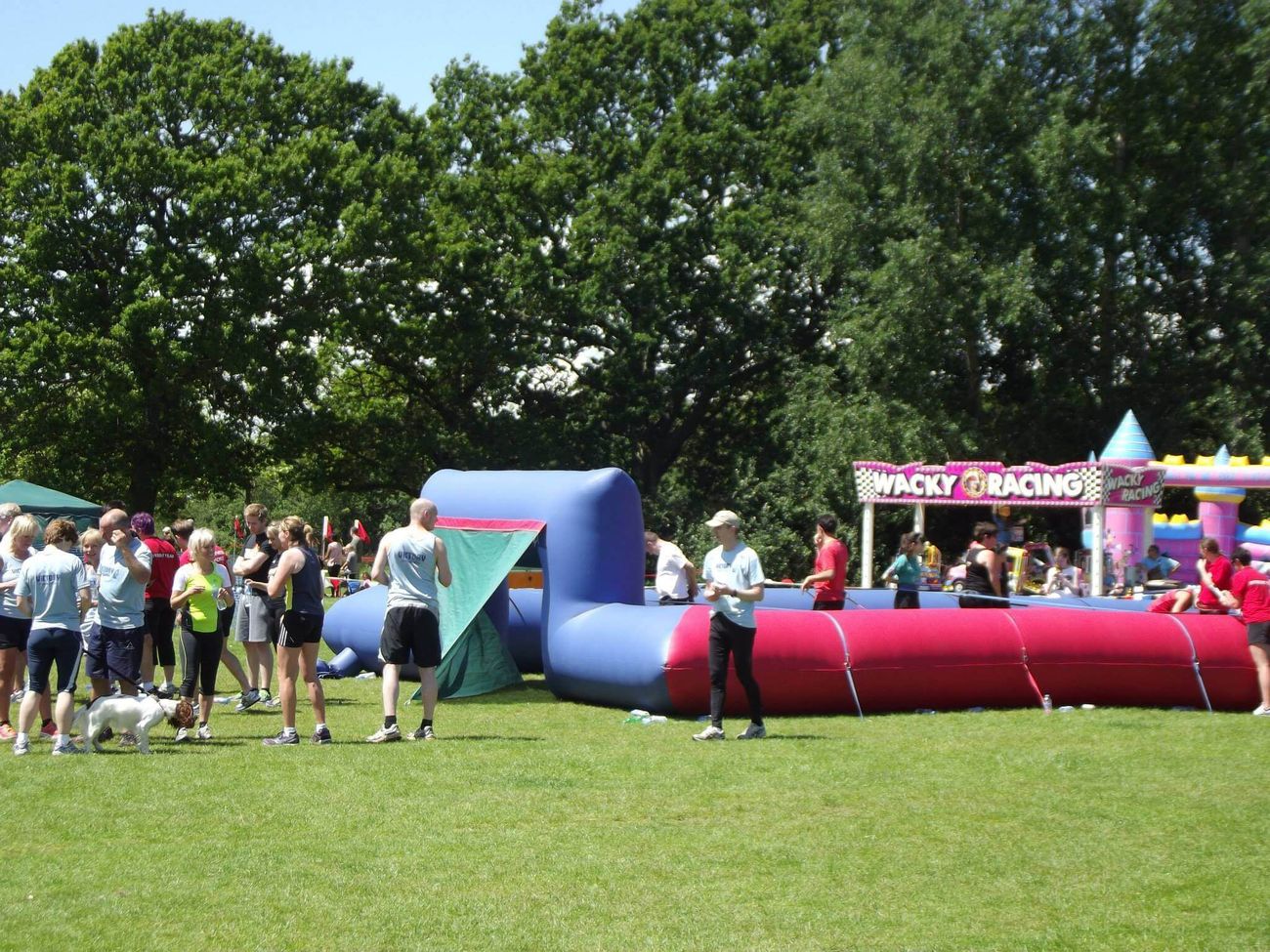 Human table football ropes set up at a busy outdoor fun day with a crowd watching