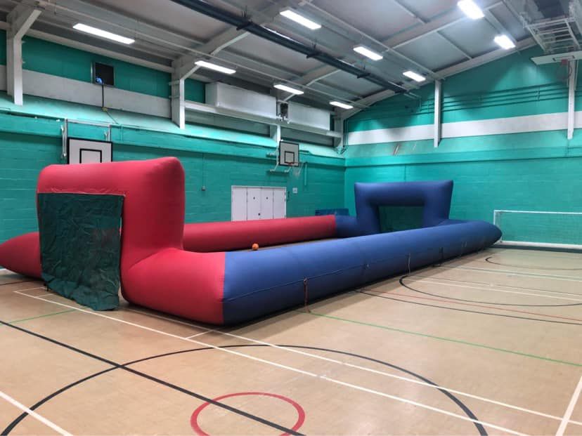 Human table football ropes set up indoors on a sports hall floor