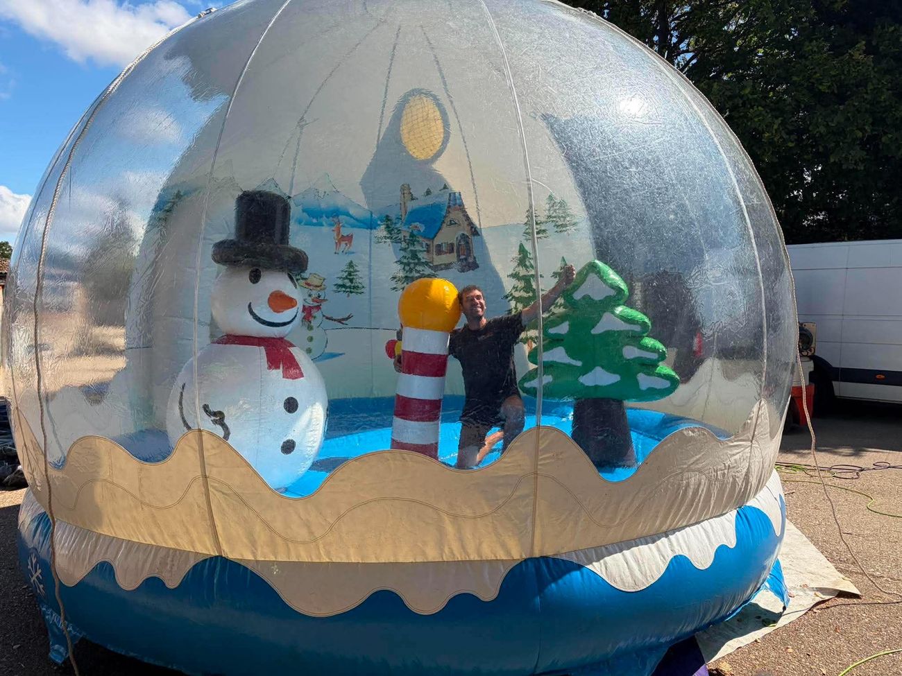 Inflatable snow globe with snowman, Christmas tree and North Pole inside, set up on hardstanding