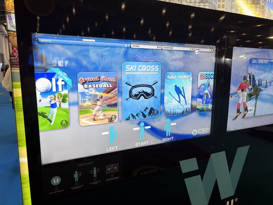 Ski Cross on the iWall menu at an exhibition, with gameplay on the side screen