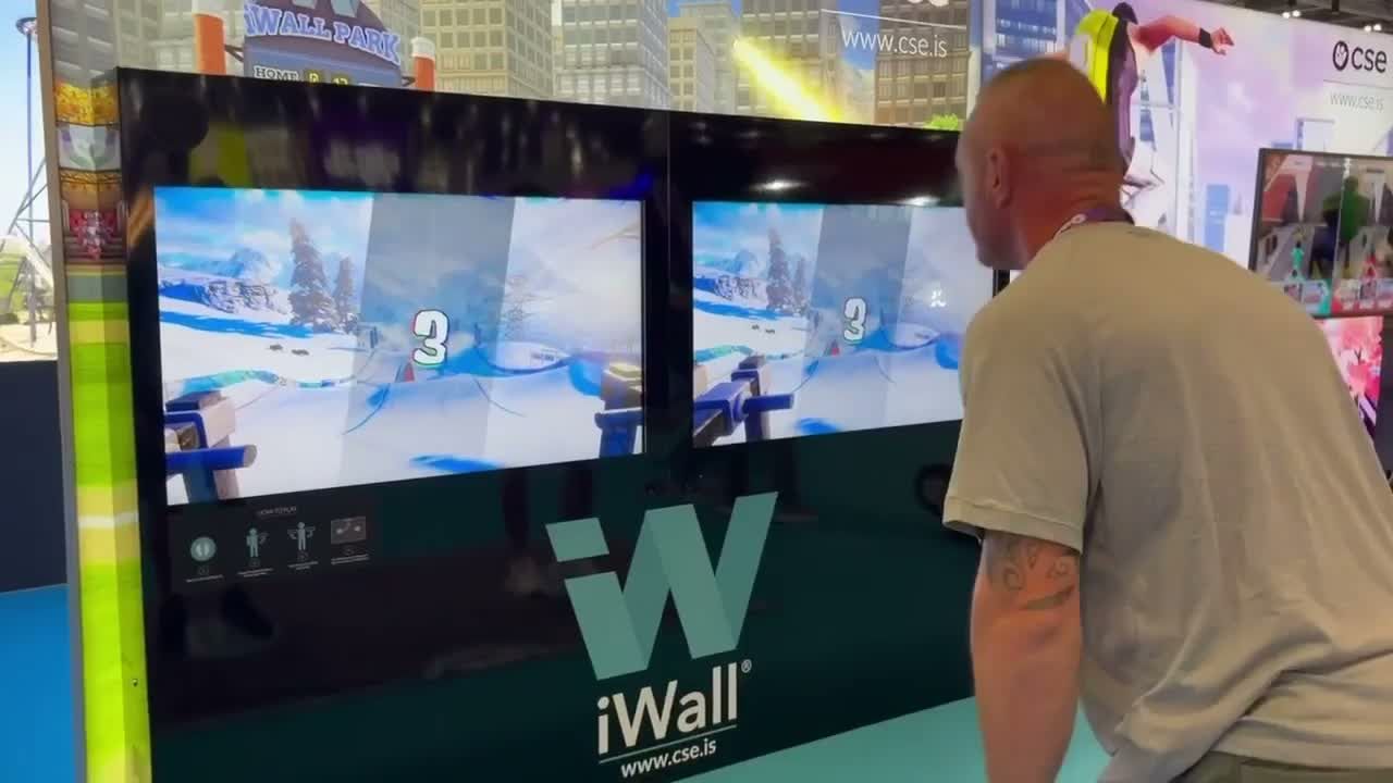 Player skiing on the iWall at an exhibition, moving in front of the screens