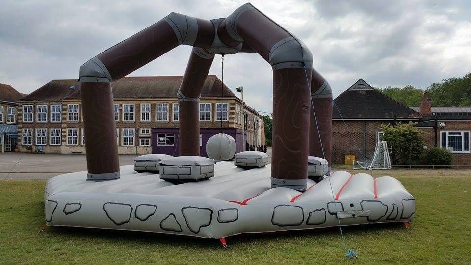 Medieval Human Demolition inflatable set up empty on a school field, arch and four pedestals