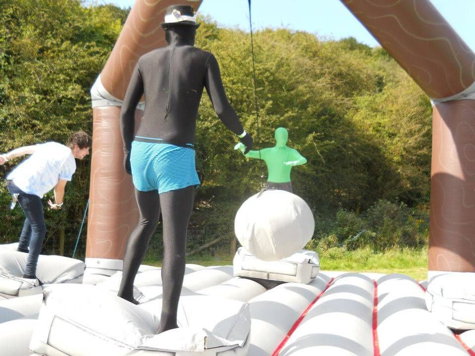 Players in morphsuits grabbing the swinging padded ball mid-game