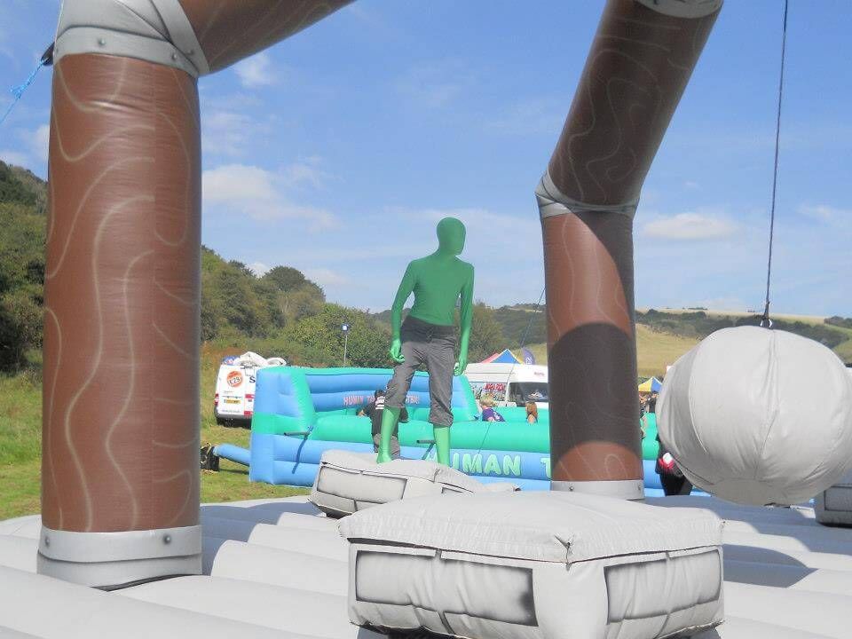 A player on a pedestal at a festival with Human Table Football set up behind