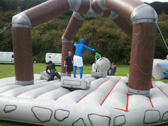 Players mid-game with an adult supervising on the inflatable base
