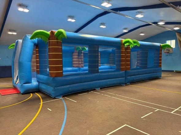Blue Multi Sports Arena with palm-tree pillars set up across a school sports hall