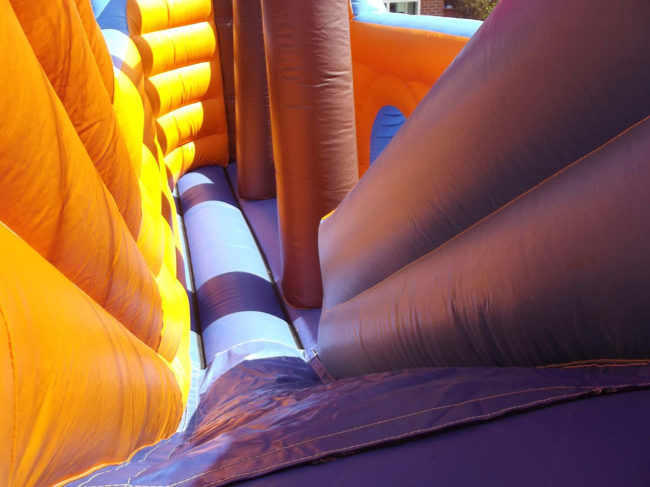Close-up of the pirate ship inflatable's yellow slide chute and striped roller