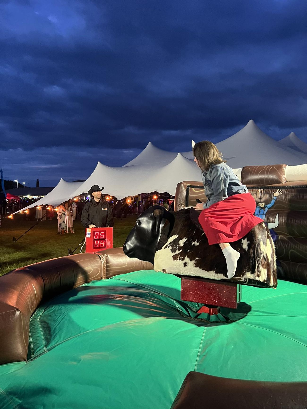 Rider on the mechanical rodeo bull during a night-time event