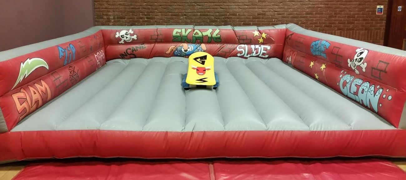 Graffiti-themed skateboard simulator bed with central yellow board showing red bull face