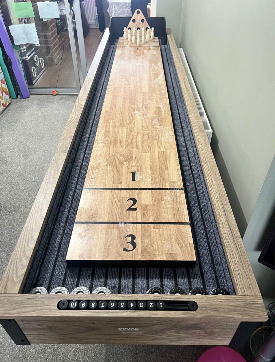 Long wooden table skittles game with scoring zones and pins