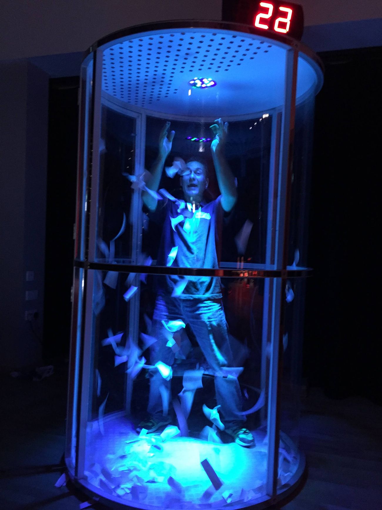 a man inside the LED lit cash grabber cube
