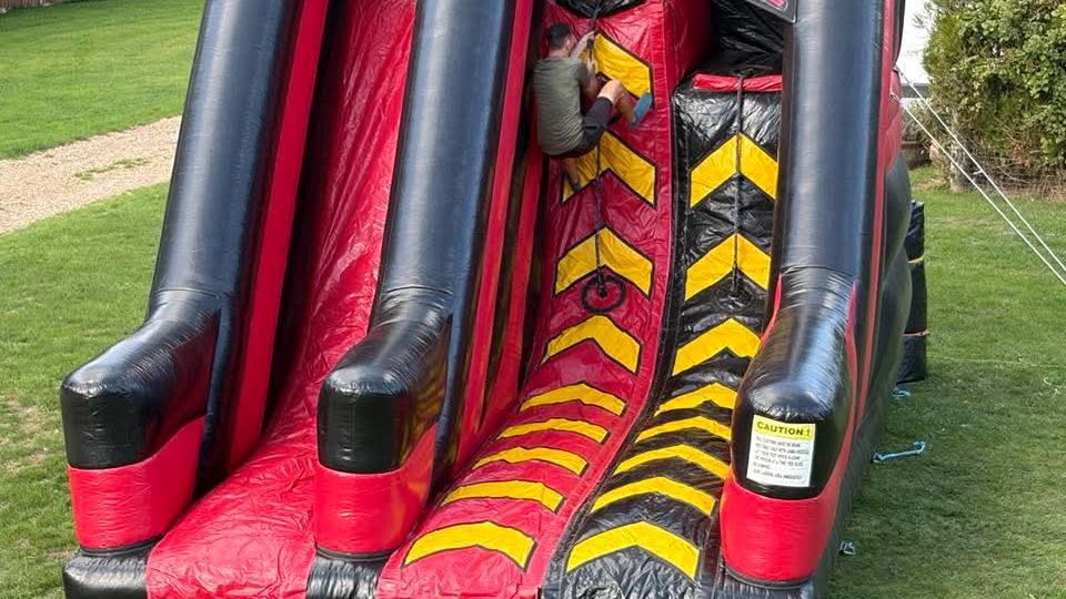 Climber partway up the Warrior Wall inflatable climbing lanes