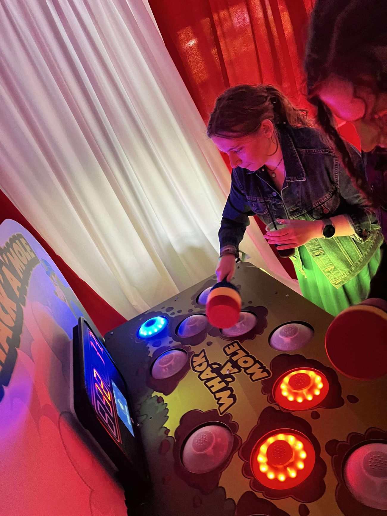Player using a foam hammer on the Whack A Mole light-up reaction game