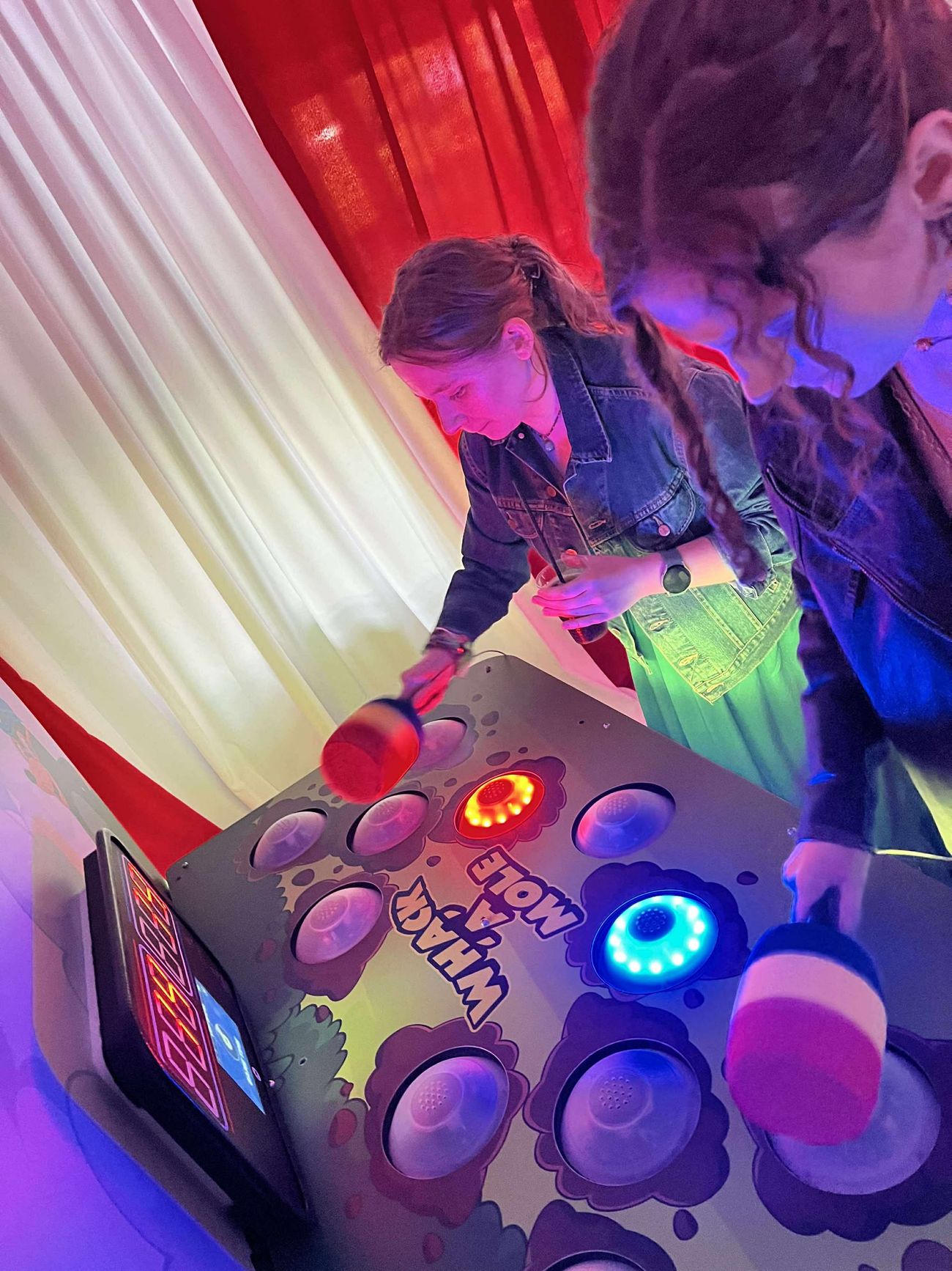 Two-player Whack A Mole game with illuminated buttons during an event