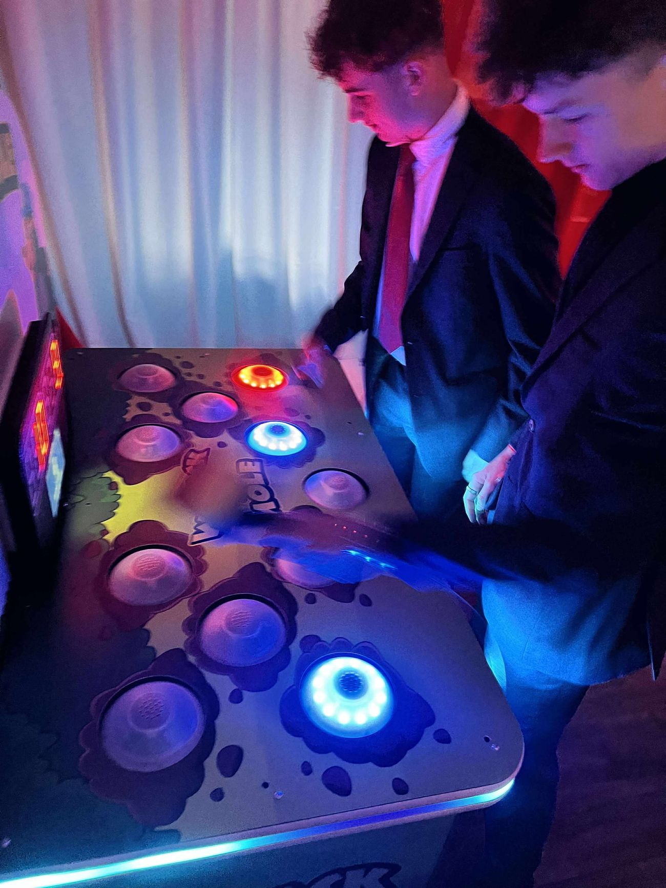 Two players competing on the Whack A Mole arcade reaction game