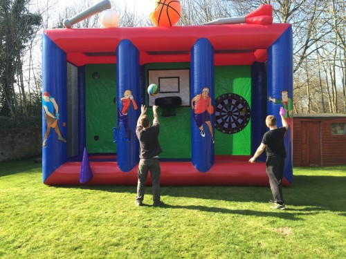 two boys throwing a basketball and a giant dart on the 3-in1 sports inflatable game