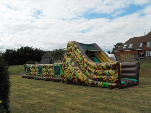 60ft army assault inflatable course in the backgarden of a house