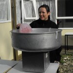 a lady making some candy floss on a large candy floss maker