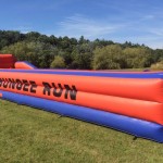 red and blue bungee run inflatable in a field